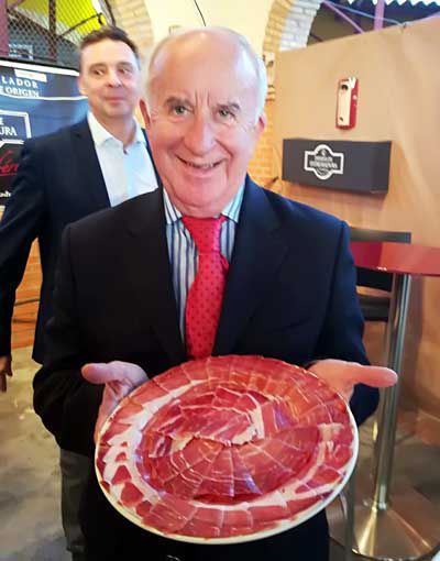 El presidente de APTEX y miembro del jurado, Juan Pedro Plaza, muestra un plato de jamón